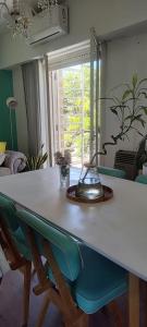 a dining room table with blue chairs and a lamp at Departamento luminoso frente a plaza con balcón in La Plata