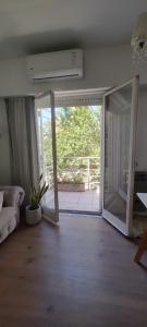 a living room with an open sliding glass door at Departamento luminoso frente a plaza con balcón in La Plata