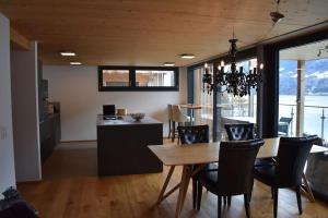 a dining room and kitchen with a table and chairs at Lina - Lakeview Living near Interlaken in Niederried +38 photos