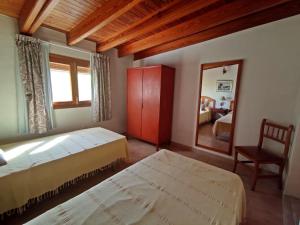een slaapkamer met 2 bedden, een spiegel en een stoel bij Ca n'Antonia in Sant Ferran de Ses Roques