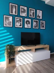 Una sala de estar con un televisor en una pared azul. en Maja & Ermes, en Pescara