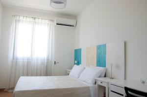 una camera con letto, scrivania e finestra di Aliseo B&B a Lecce