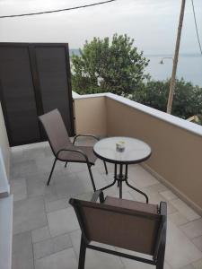 a patio with a table and chairs on a balcony at Varkaris Room 3 in Katarráktis