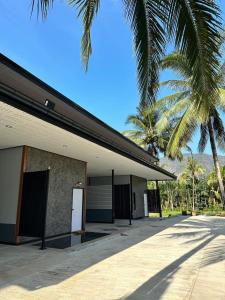 un edificio con una puerta blanca y una palmera en Phangnga Save House - เซฟเฮาส์พังงา, en Phang Nga