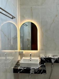 uma casa de banho com um lavatório branco e um espelho. em Phangnga Save House - เซฟเฮาส์พังงา em Phangnga