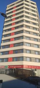 a tall building with a red stripe on it at Hightower Apartment in Floreşti