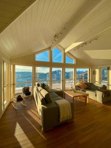 uma sala de estar com um sofá e algumas janelas em Cabin at Gaustatoppen, hiking opportunities, sauna em Tuddal