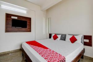 班加羅爾的住宿－OYO 82074 Hotel Aishwarya Comfort，一间卧室配有一张床铺,床上铺有红色毯子