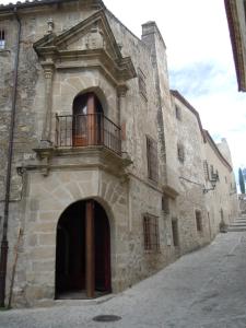 un gran edificio de piedra con balcón. en Palacio Chaves Hotel, en Trujillo