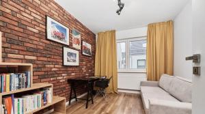 uma sala de estar com uma parede de tijolos e um sofá em Stylish Two-story Apartment - Nowy Oltaszyn em Iwiny