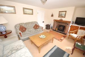 sala de estar con sofá y chimenea en Romany Rye, en Sheringham