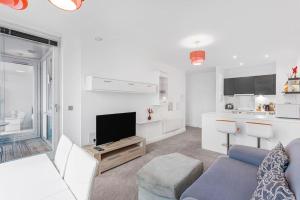 a white living room with a couch and a tv at High Spec 2 Bed, 2 Bath, Wi-Fi, Balcony in Hemel Hempstead