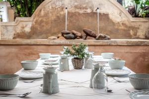 uma mesa com uma toalha de mesa branca e pratos sobre ela em Petite Provence B&B em Ballito