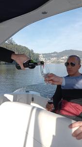 Ein Mann, der ein Glas Wein auf ein Boot gießt. in der Unterkunft Sunset River - Douro in Porto
