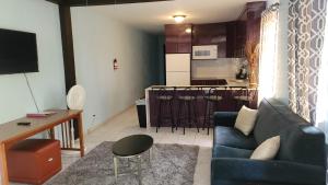a living room with a blue couch and a kitchen at CHIC Family-friendly home sleeps up to 12 People, Right Unit in Catano