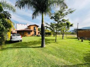 a car parked in front of a house with a palm tree at Casa Las Animas Malinalco in Malinalco