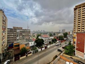 uma vista para uma rua da cidade com edifícios e carros em A 5 minutos do aeroporto! La Vie com estacionamento privado em Luanda