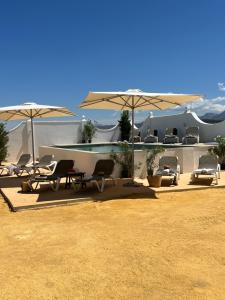 un grupo de sillas y sombrillas en un patio en Cortijo El Solano, en Antequera