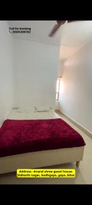 ブッダガヤにあるAnand Innのベッドルーム1室(赤い毛布付きのベッド1台付)
