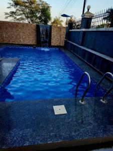 a swimming pool with a sign in the water at ReUnion Villa ll Swimming Pool ll Snooker ll AC ll BBQ ll 3BHK in Lonavala