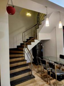 a staircase with a glass table and chairs at ReUnion Villa ll Swimming Pool ll Snooker ll AC ll BBQ ll 3BHK in Lonavala