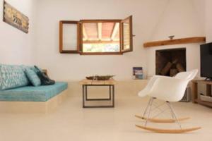 a living room with a blue couch and a white chair at A beautiful villa close to the beach in Playa Migjorn
