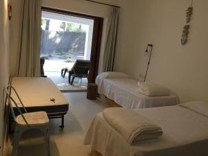 a hotel room with two beds and a window at A beautiful villa close to the beach in Playa Migjorn
