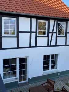 un edificio blanco y negro con ventanas y un banco en Ferienhaus auffm Hebberg en Attendorn