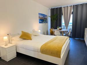 a bedroom with a large white bed and a table at Marina Suites Tenerife in Puerto de la Cruz