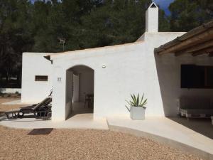 a white building with a patio with a tv at A beautiful villa close to the beach in Playa Migjorn