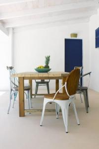 a wooden table with chairs and a bowl of fruit on it at A beautiful villa close to the beach in Playa Migjorn +34 photos