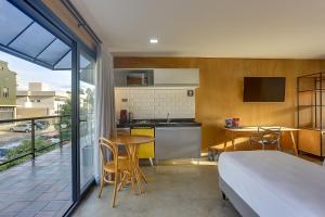 a bedroom with a bed and a kitchen with a table at Hotel 1948 in Holambra +36 photos