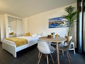 a hotel room with a bed and a table with chairs at Marina Suites Tenerife in Puerto de la Cruz