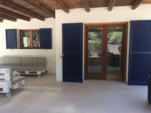 a room with blue doors and windows at A beautiful villa close to the beach in Playa Migjorn