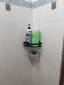 a tiled bathroom with two bottles of detergent on a shelf at 5-Person 1950s Shophouse: Vintage Charm & Smart TVs in Taiping