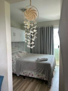 a bedroom with a bed and a chandelier at Studio A completo 400m da praia in Porto De Galinhas