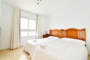 two white beds in a bedroom with a window at Expoholidays - Puerto Deportivo La Goleta in Almerimar +42 photos