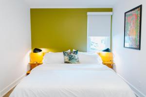 a bedroom with a large white bed with two lamps at The Vinyl at Music Row - 1 Bedroom Apartment in Nashville