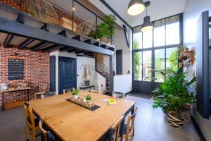 a dining room with a wooden table and some plants at ATELIER 19 Maison d'Hôtes in Varesnes