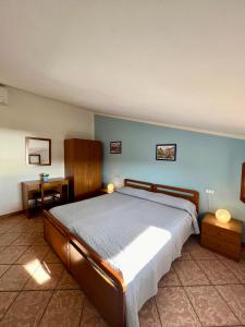 a bedroom with a large bed with blue walls at Case Vacanze Maestrale in Fetovaia