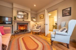 a living room with a fireplace and two chairs at Norfolk House 2 in Heacham