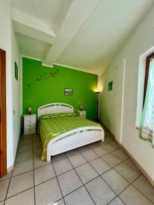 a green bedroom with a bed and a green wall at Case Vacanze Maestrale in Fetovaia