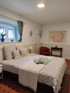 1 dormitorio con 1 cama grande y 1 silla roja en Domaine des Prés de Joussac - Protocole sanitaire strict, en Jau-Dignac-et-Loirac