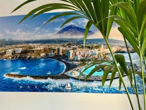a view of the city of fuerteventura with a palm tree at Marina Suites Tenerife in Puerto de la Cruz