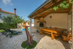 a patio with a large wooden table and a bench at Villa Cera Dignano in Vodnjan