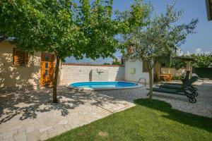a backyard with a swimming pool and trees at Villa Cera Dignano in Vodnjan