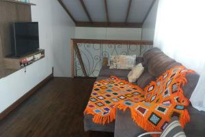 ein Wohnzimmer mit einem Sofa und einem TV in der Unterkunft Linda casa de praia 5km Beto Carrero - Gravatá. 300 metros da praia!! in Navegantes