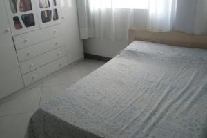 um pequeno quarto com uma cama e uma cómoda em Linda casa de praia 5km Beto Carrero - Gravatá. 300 metros da praia!! em Navegantes