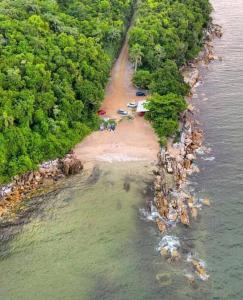 una vista aerea di una spiaggia con tende e alberi di Linda casa de praia 5km Beto Carrero - Gravatá. 300 metros da praia!! a Navegantes