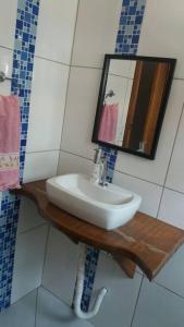 ein Bad mit einem Waschbecken und einem Spiegel in der Unterkunft Linda casa de praia 5km Beto Carrero - Gravatá. 300 metros da praia!! in Navegantes